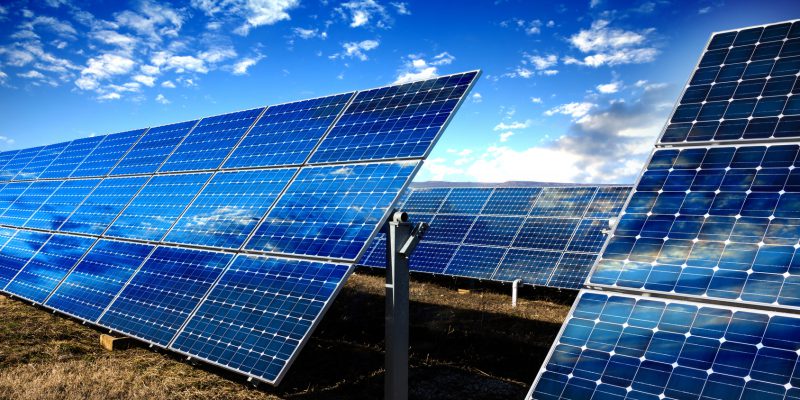 Row of photovoltaic solar panels and sky background